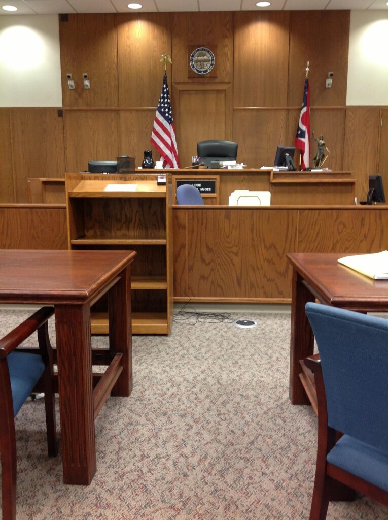 Courtroom setting featuring a judge's bench with U.S. flag