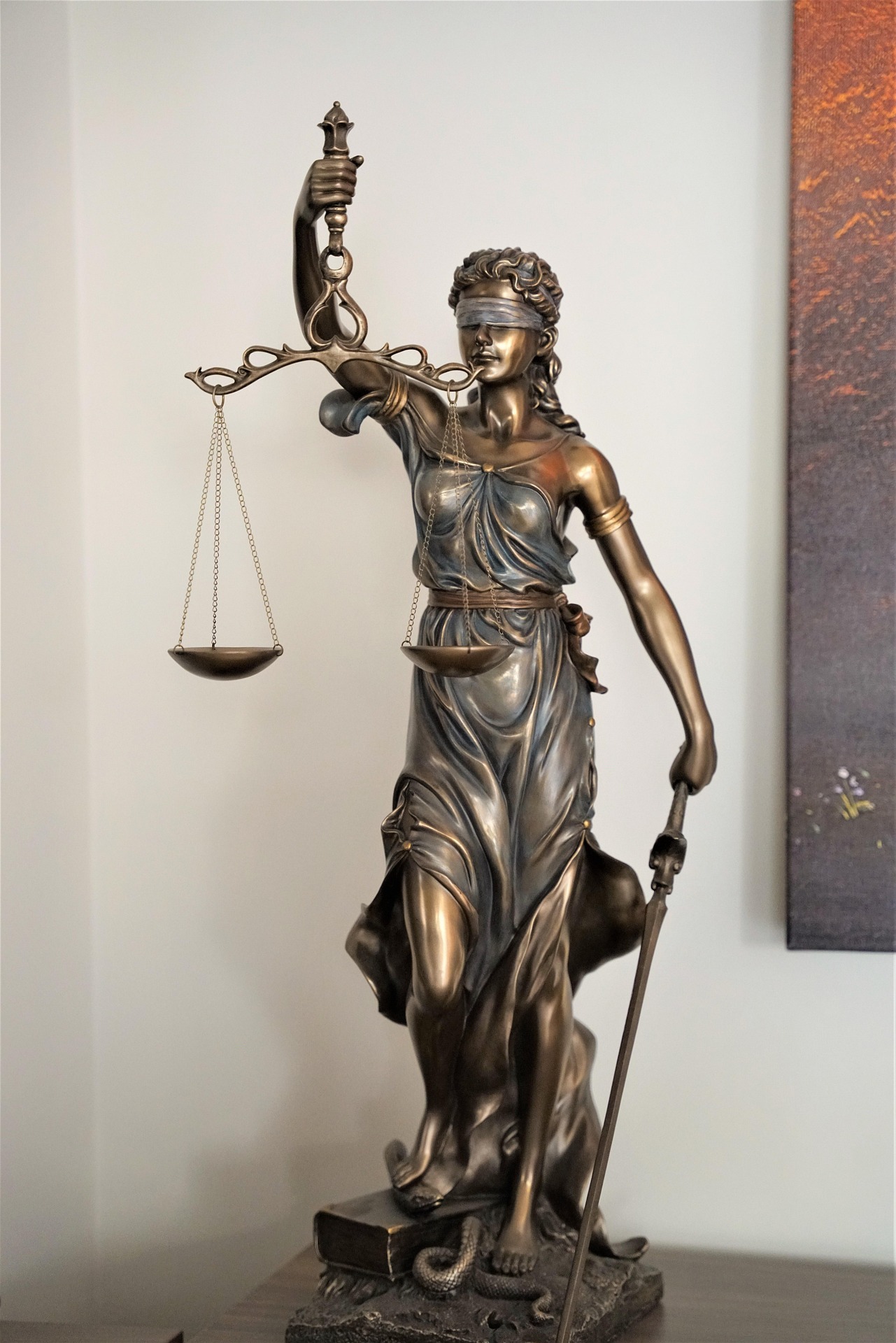 Bronze statue of Lady Justice, blindfolded, holding scales and a sword, symbolizing fairness and the rule of law.
